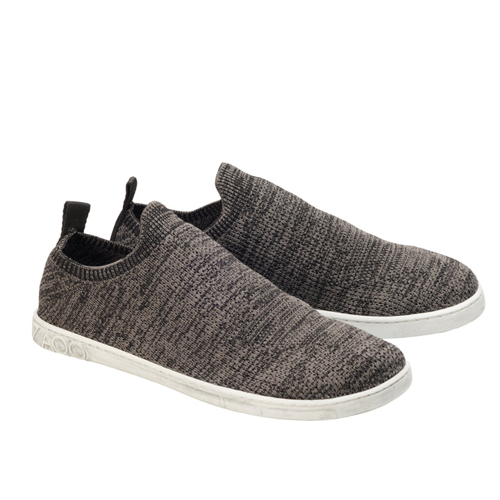 Aus der Perspektive betrachtet offenbaren die ZAQQ SQIN Grey Sneaker ihre gestrickte Textilgewebe-Textur im Slip-On-Design, akzentuiert durch die weißen Gummisohlen.