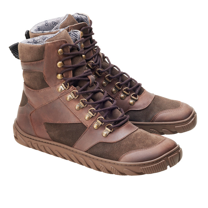 Die ZAQQ EXPLORER Brown Waterproof Wanderstiefel sind High-Top-Schuhe aus dunkelbraunem Wildleder mit Lederpatches, Metallösen und -haken, einer strukturierten Gummisohle und einem gepolsterten grauen Innenfutter, ideal für Outdoor-Enthusiasten.