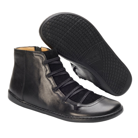 Wir präsentieren den Quechee Black von ZAQQ – ein stilvolles Paar schwarzer High-Top-Schuhe mit mittlerem Schnitt. Ein Schuh steht aufrecht, um sein elegantes Design und die Schnürdetails hervorzuheben, während der andere seine strukturierte Sohle offenbart.