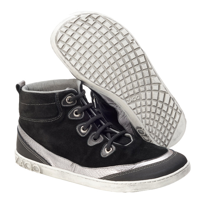 Die ZAQQ CINQO Black High-Top-Sneaker aus glattem Veloursleder haben weiße Sohlen und silberne Akzente. Der linke Sneaker steht aufrecht und betont seine Schnürsenkel und das seitliche Design, während der rechte Sneaker leicht geneigt ist und das bezaubernde Waffelmuster auf der Sohle offenbart.