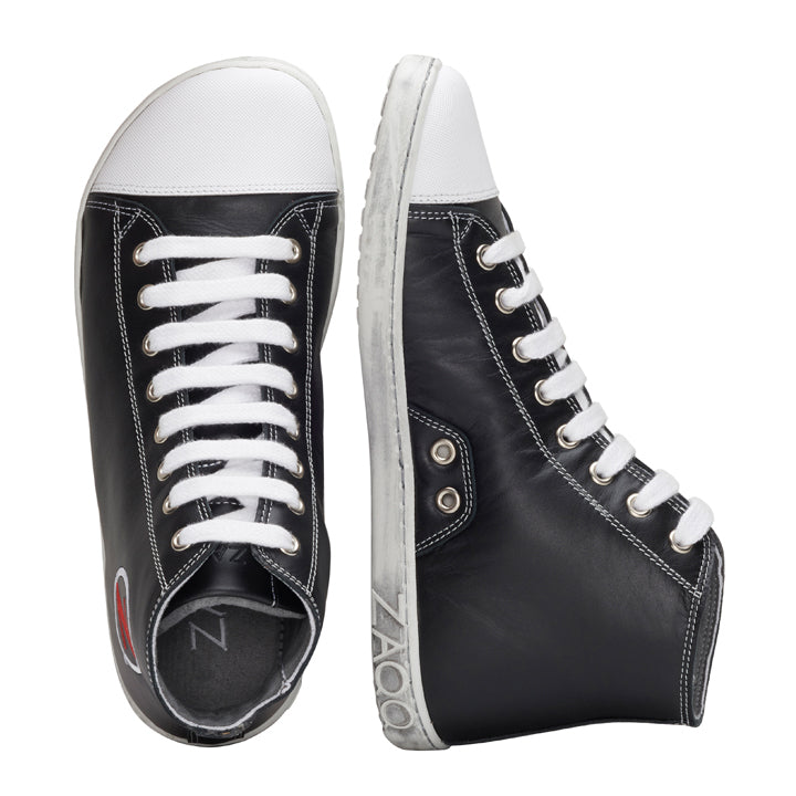 Ein Paar stylische schwarze High-Top-Sneaker von ZAQQ CHUQQS mit weißer Kautschuksohle und Schnürsenkeln. Der linke Schuh steht aufrecht, während der rechte Schuh auf der Seite liegt und ein schickes Logo in der Nähe der Ferse zeigt.