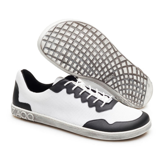 Wir präsentieren die veganen DUPLEQ Black White Sneaker von ZAQQ in elegantem Schwarz-Weiß-Design mit strukturierter Sohle. Diese stylischen Barfußschuhe sind aus atmungsaktivem schwarz-weißem Mesh-Gewebe für mehr Komfort gefertigt und verfügen über Schnürdetails, die stolz das ZAQQ-Logo an der Seite zeigen.