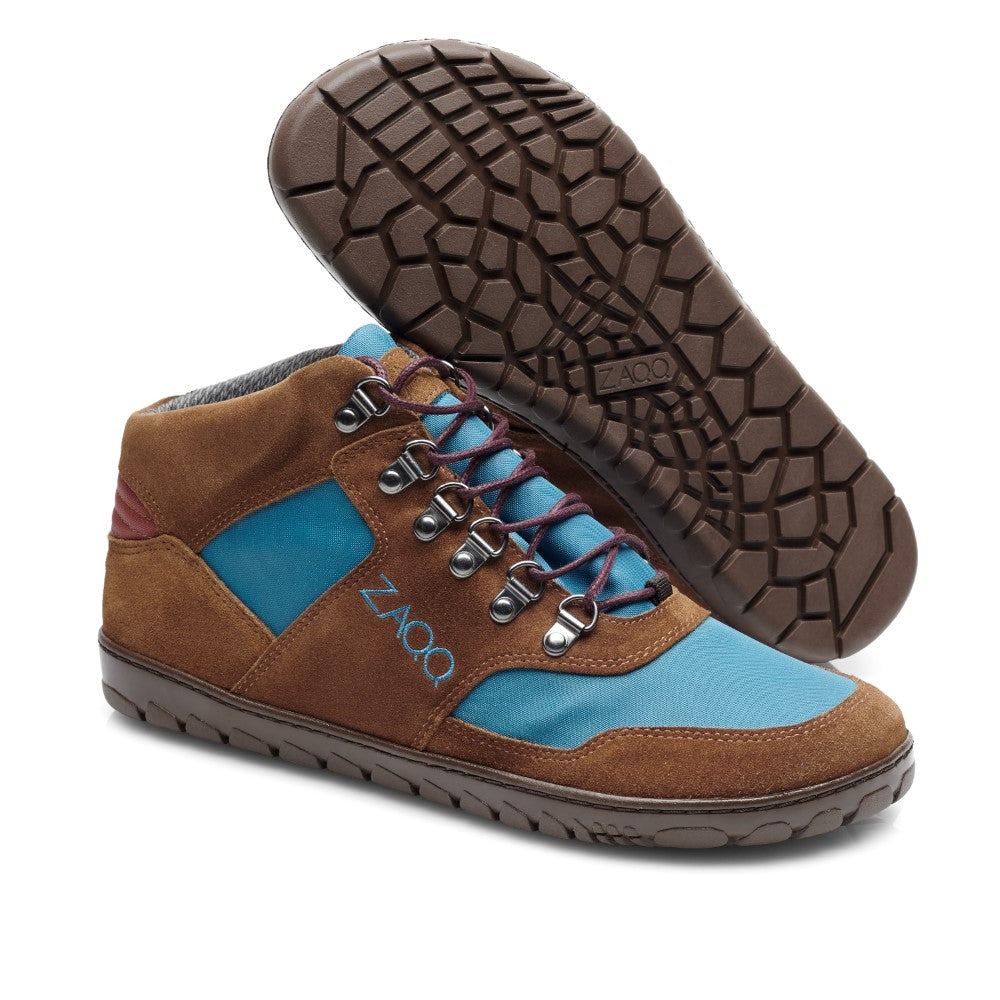 Die HIQE Mid Blue Marine Waterproof-Schuhe von ZAQQ zeichnen sich durch ein stilvolles braun-blaues Design mit strukturierten Sohlen und blauen Schnürsenkeln aus, das sowohl in der Seitenansicht als auch in der Sohlenansicht dargestellt ist. Der Markenname ZAQQ ist auf der Seite des Schuhs sichtbar.