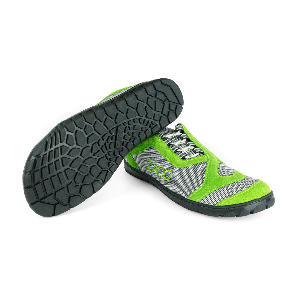 Wir präsentieren den QUIQ Trail Green von ZAQQ: eine ideale Wahl für Outdoor-Abenteuer, bestehend aus limettengrünen und grauen Sportschuhen mit auffälligen schwarzen Sohlen. Der linke Schuh ist angewinkelt, um das komplizierte Strukturmuster der Sohle zu zeigen, während der rechte Schuh hoch steht und die stilvolle „1.000“ auf seiner Seite zur Schau stellt. Tragekomfort verschmilzt mühelos mit Stil in diesem anspruchsvollen Design.