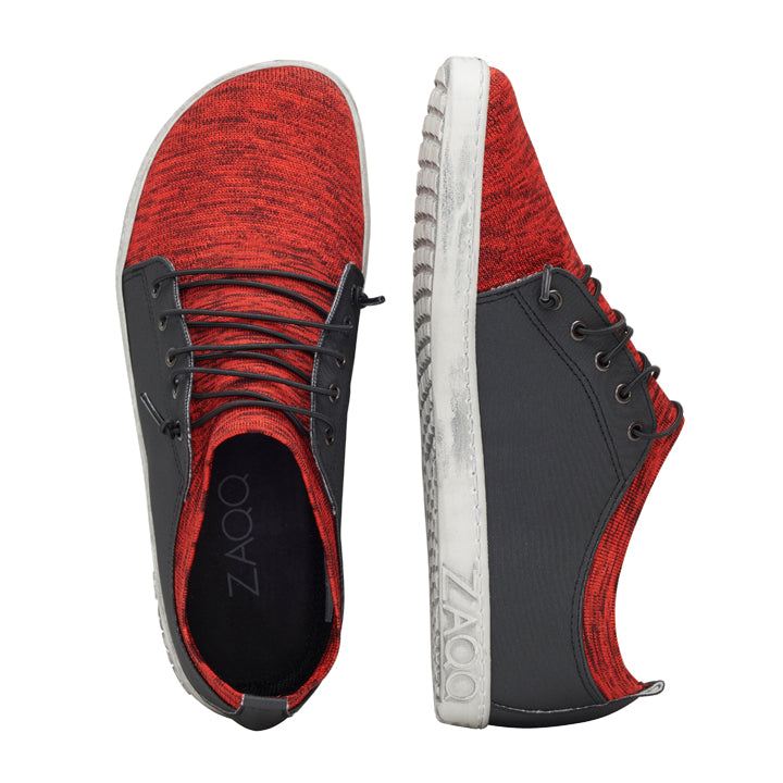 Wir präsentieren die QRIS Red Sneaker von ZAQQ – diese stylischen Barfußschuhe zeichnen sich durch ein auffälliges rot-schwarzes Design mit weißer Sohle aus. Ein Schuh wird von oben präsentiert und hebt seine sauberen Schnürsenkel hervor, während der andere sein strukturiertes Gewebe und die kontrastierende Sohle zur Schau stellt. Auf der Innensohle ist der Markenname ZAQQ deutlich zu sehen, was sie perfekt für jeden Sneaker-Liebhaber macht.