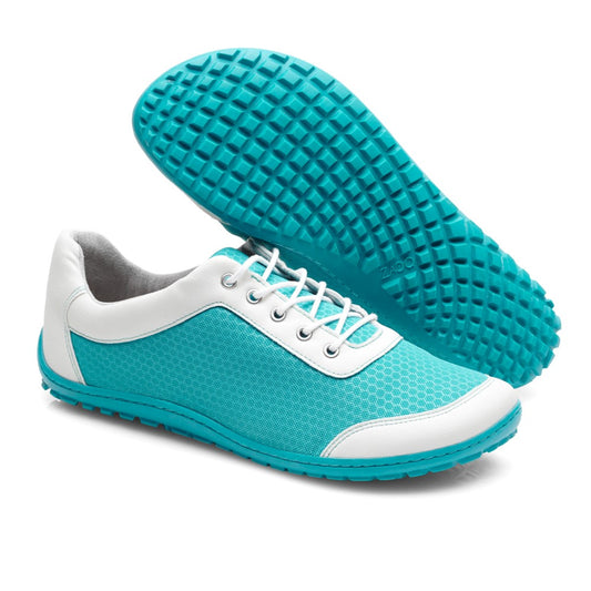 Die SQIP Turquoise Sneaker von ZAQQ werden ausgestellt, wobei ein Schuh aufrecht steht, um die Netzstruktur und die weißen Schnürsenkel aus veganen Materialien hervorzuheben. Der andere Schuh ist angewinkelt, um die Sohle mit Waffelmuster hervorzuheben, ideal für ein Lauferlebnis im Freien.