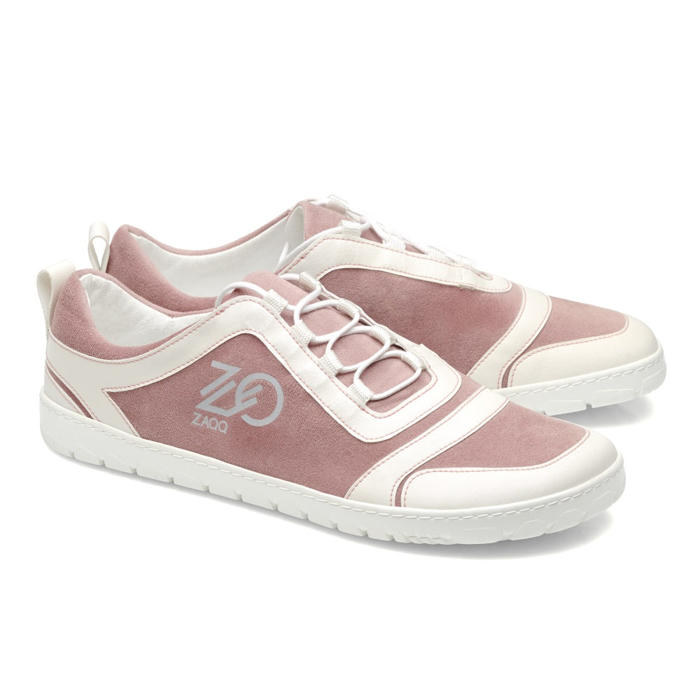 Wir präsentieren die SQILL Rose von ZAQQ, ein Paar stylische Sneaker in einem Farbschema aus Weiß und gedecktem Rosa, gefertigt aus veganer Mikrofaser. Diese Schuhe verfügen über ein elegantes Logo an der Seite und eine robuste weiße Sohle, ergänzt durch weiße Schnürsenkel und eine praktische Aufreißlasche an der Rückseite für einfaches Tragen.