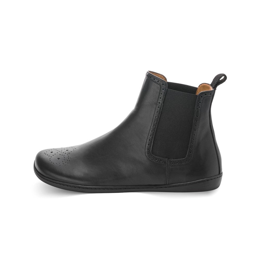 Eine Seitenansicht des ZAQQ EQUITY Brogue Black Lederstiefeletten hebt Brogue-Details an der Spitze, ein elastisches Seitenteil und eine Aufreißlasche an der Rückseite hervor. Dieser klassische Chelsea-Boot aus hochwertigem Nappaleder verfügt über eine elegante, flache schwarze Sohle.